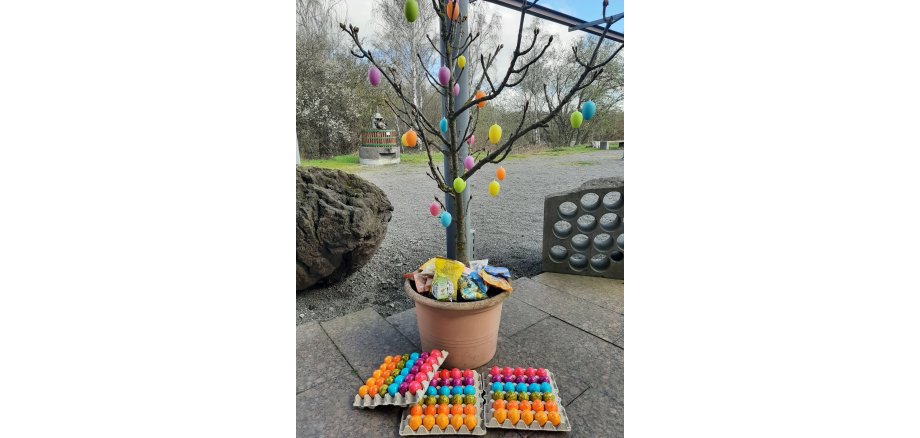 Kleiner Baum mit Ostereiern behangen und Süßigkeiten drin