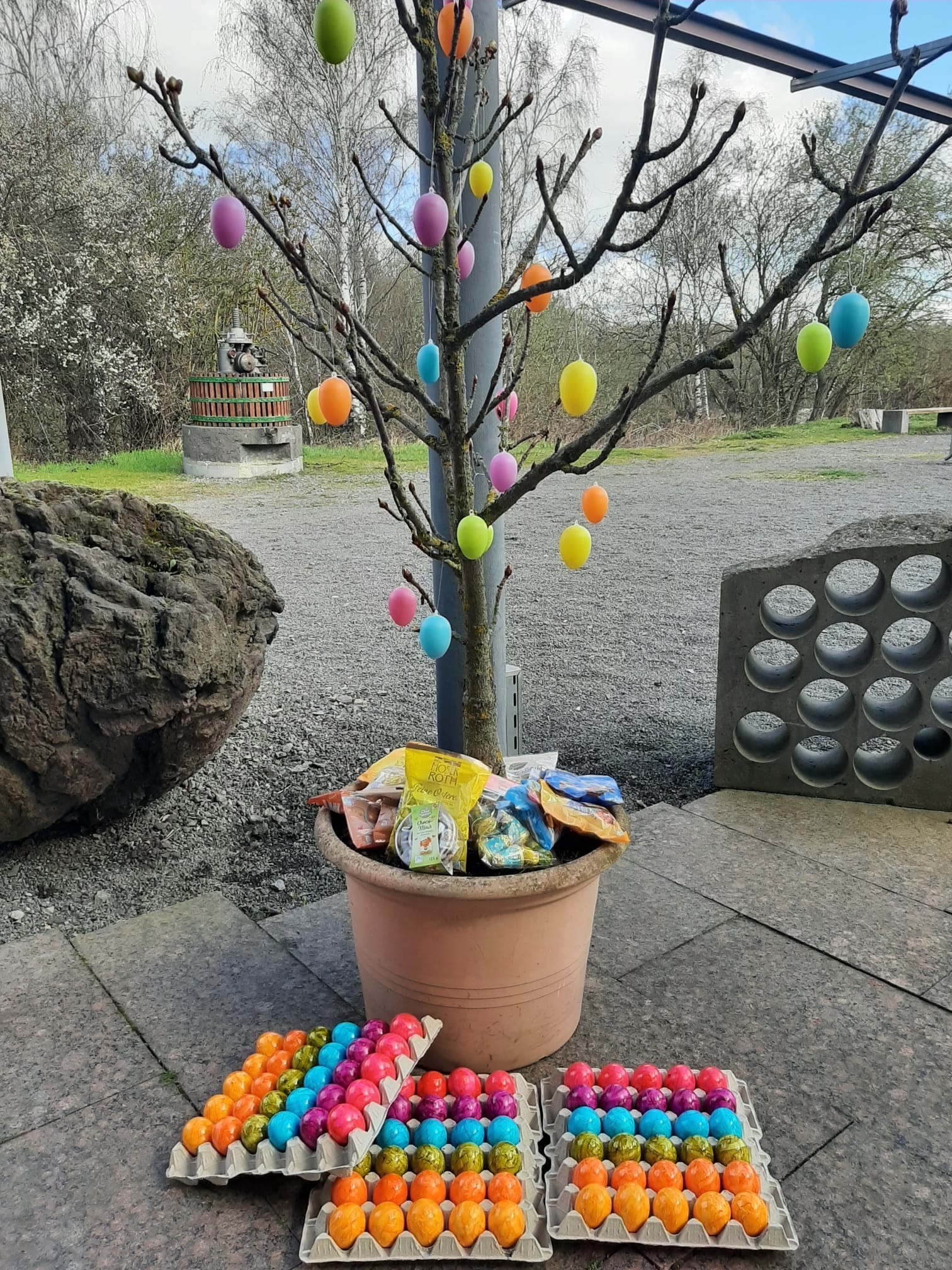 Kleiner Baum mit Ostereiern behangen und Süßigkeiten drin