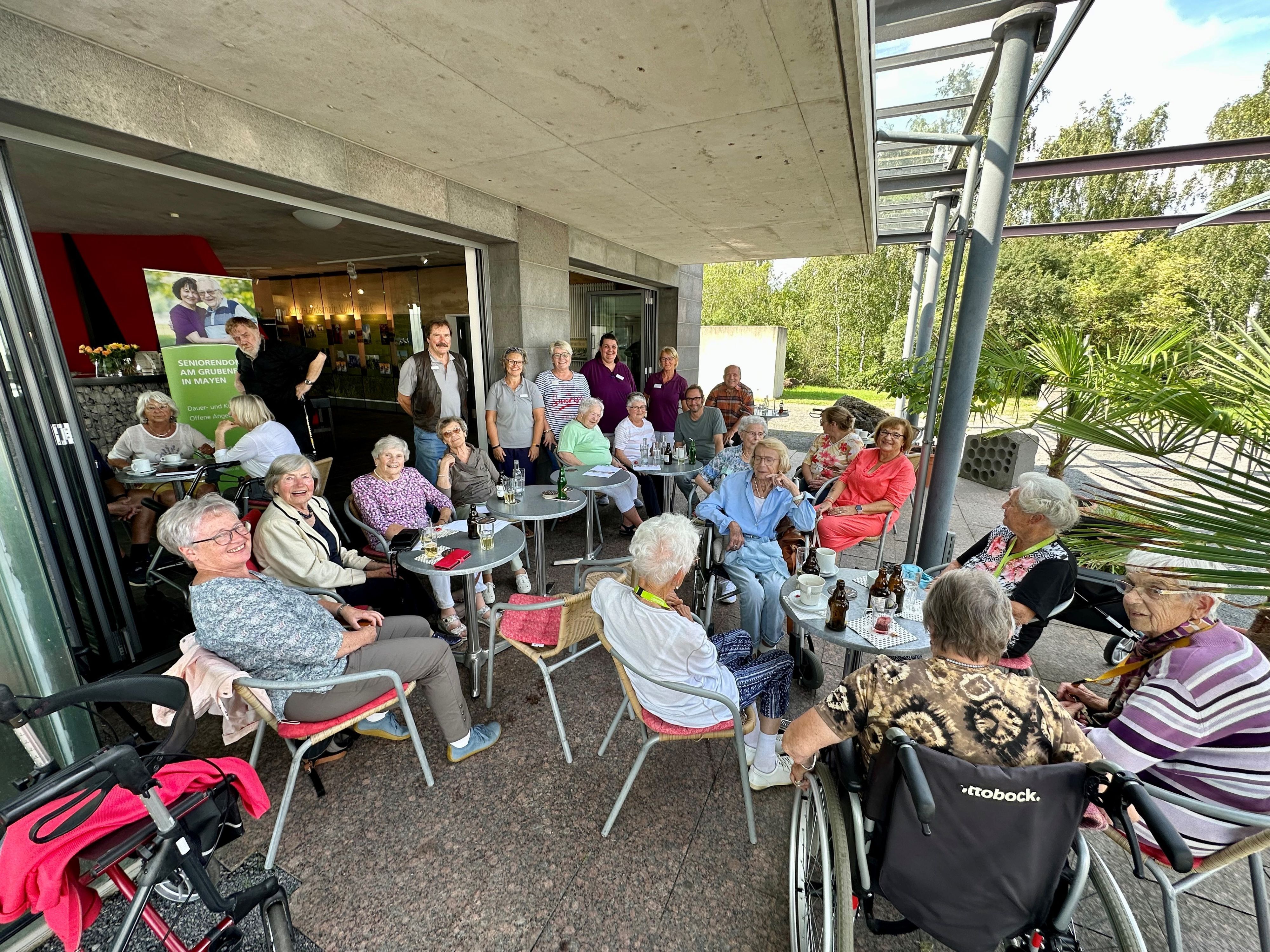 Viele Menschen sitzen bei Kaffee und Kuchen zusammen und tauschen sich aus
