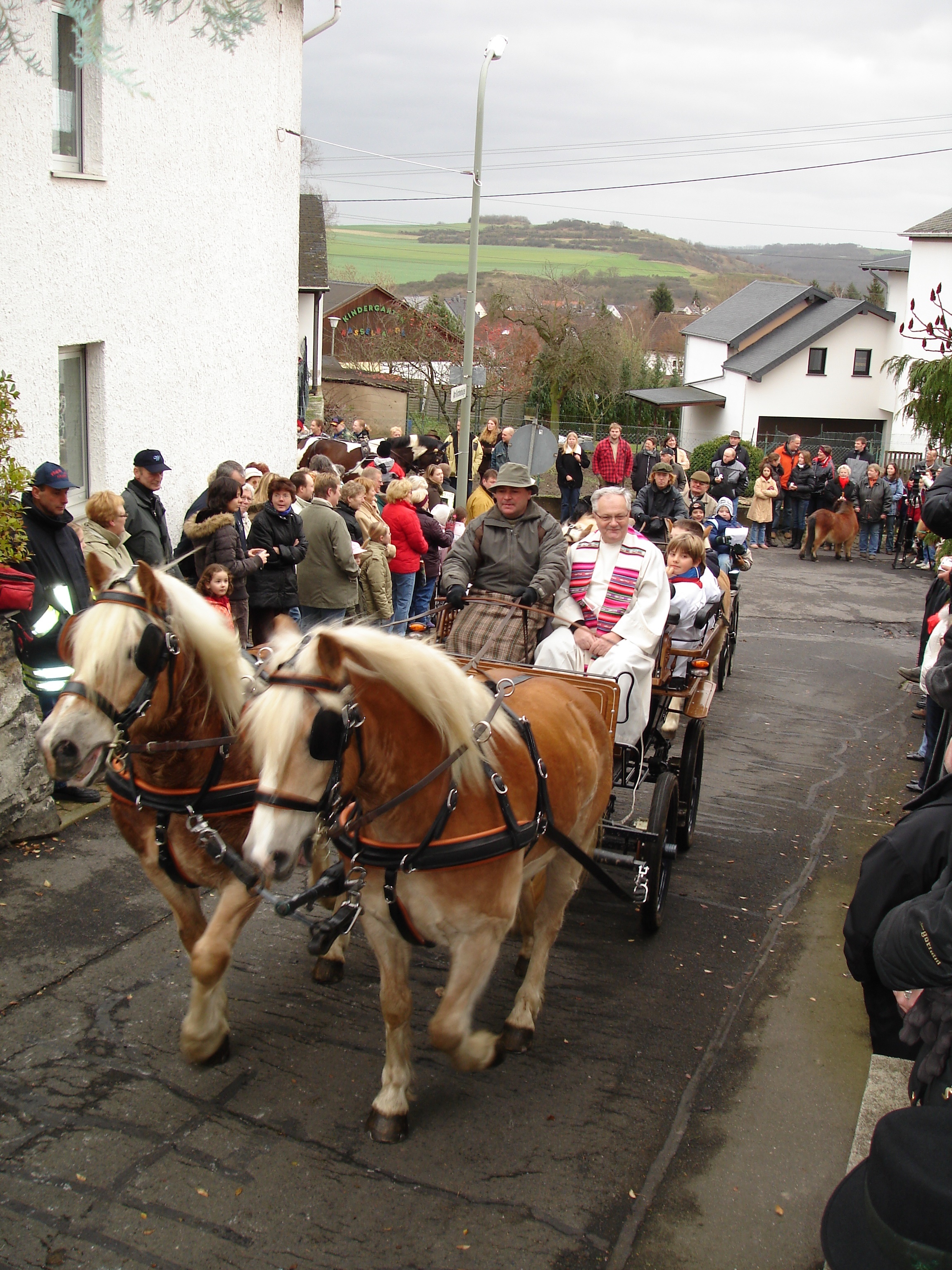 Eine Pferdekutsche mit Personen fährt durch die Hausener Straßen