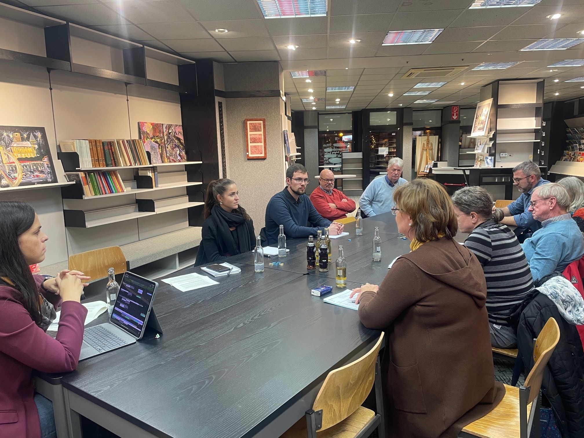 Mehrere Personen sitzen an einem Tisch zusammen und beraten