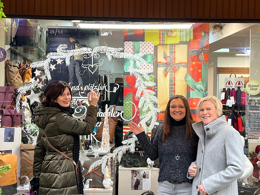 Drei Frauen vor dem bemalten Schaufenster