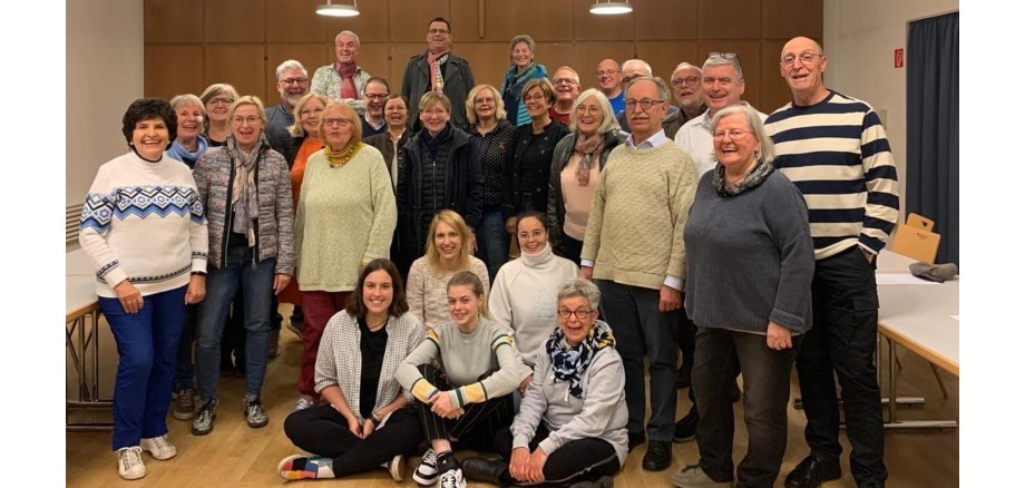 Männer und Frauen stehen zu einem Gruppenbild zusammen 