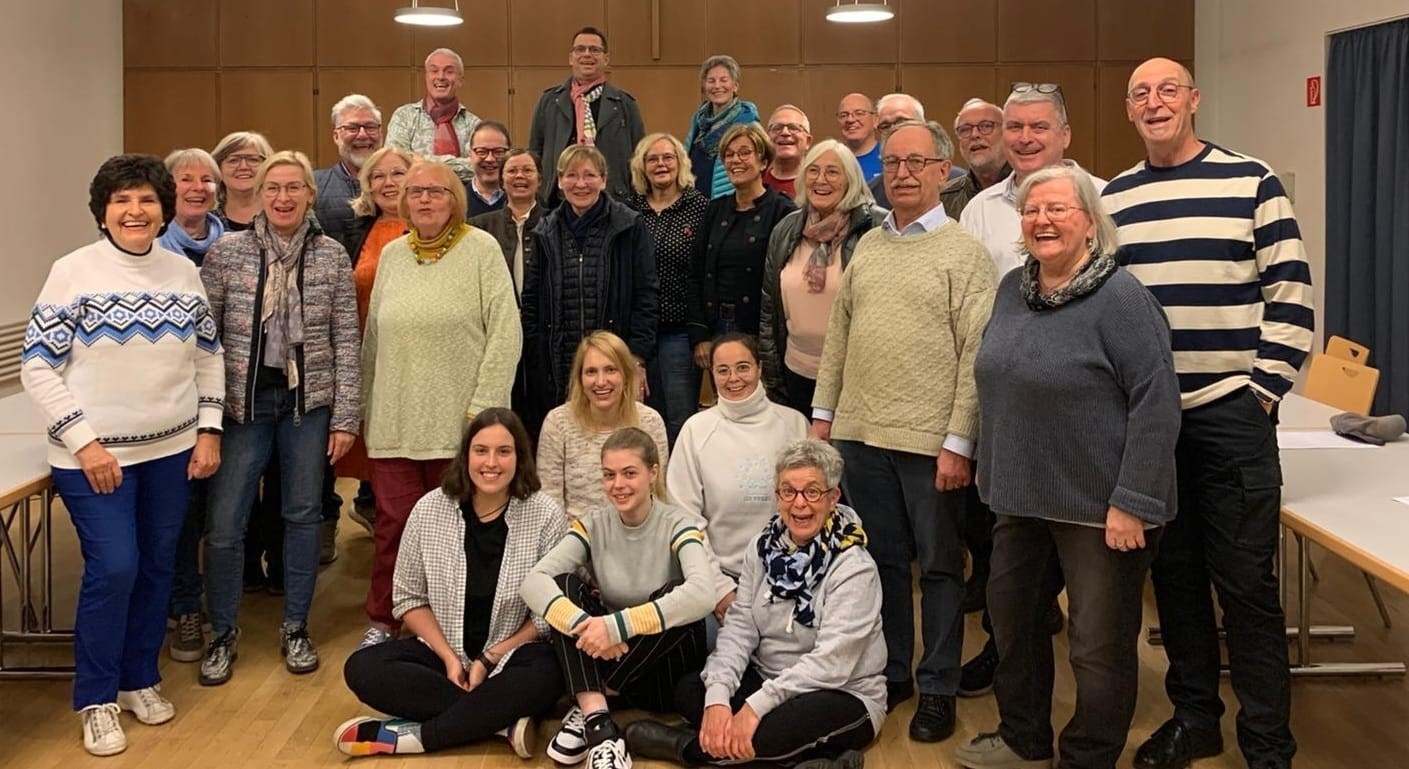Männer und Frauen stehen zu einem Gruppenbild zusammen 