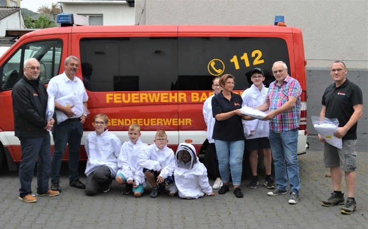 Personen stehen vor einem Bus der Feuerwehr