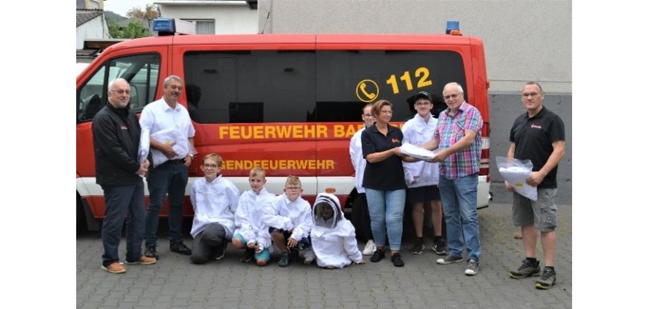 Personen stehen vor einem Bus der Feuerwehr