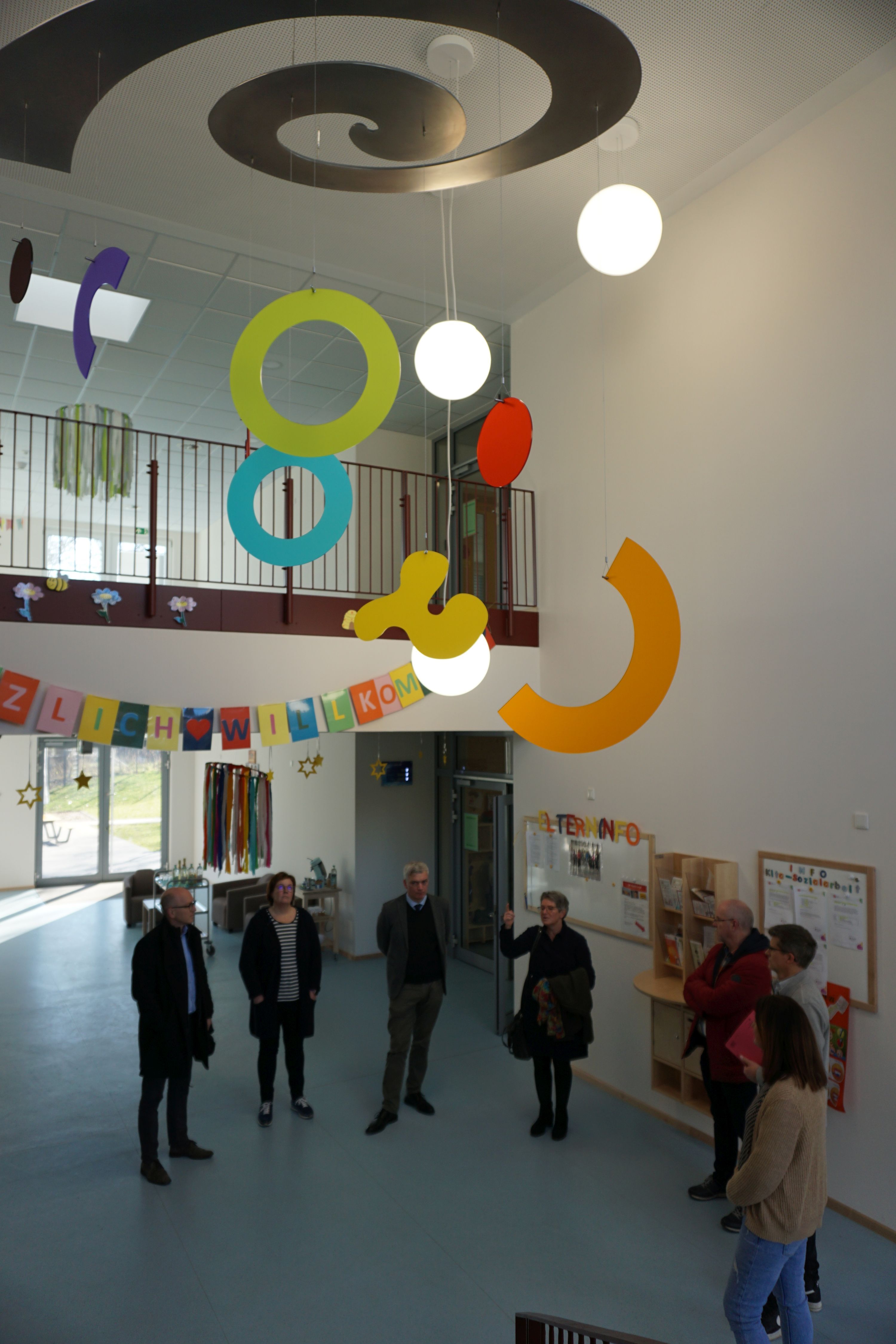 Mehrere Personen bei der Vorstellung des Kunstwerkes im Foyer der Kita "In der Weiersbach"