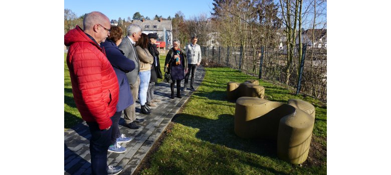 Mehrere Personen bei der Vorstellung des Kunstwerkes im Außenbereich der Kita "In der Weiersbach".