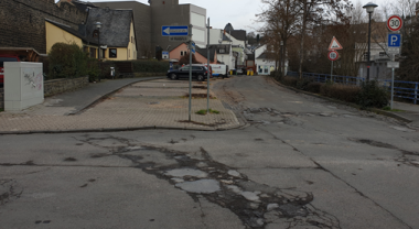 Deutlich sichtbare Beschädigungen der Straße und Anhebung des Pflasters