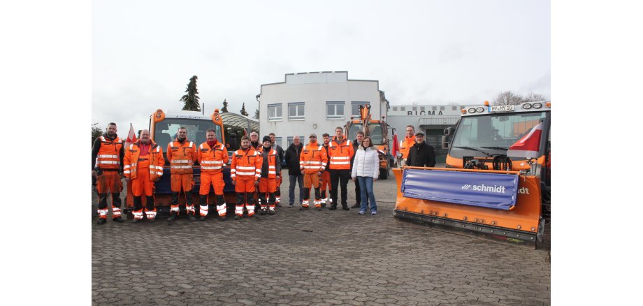 Zahlreiche Personen stehen vor Fahrzeugen des Betriebshofes - viele sind in Organge gekleidet