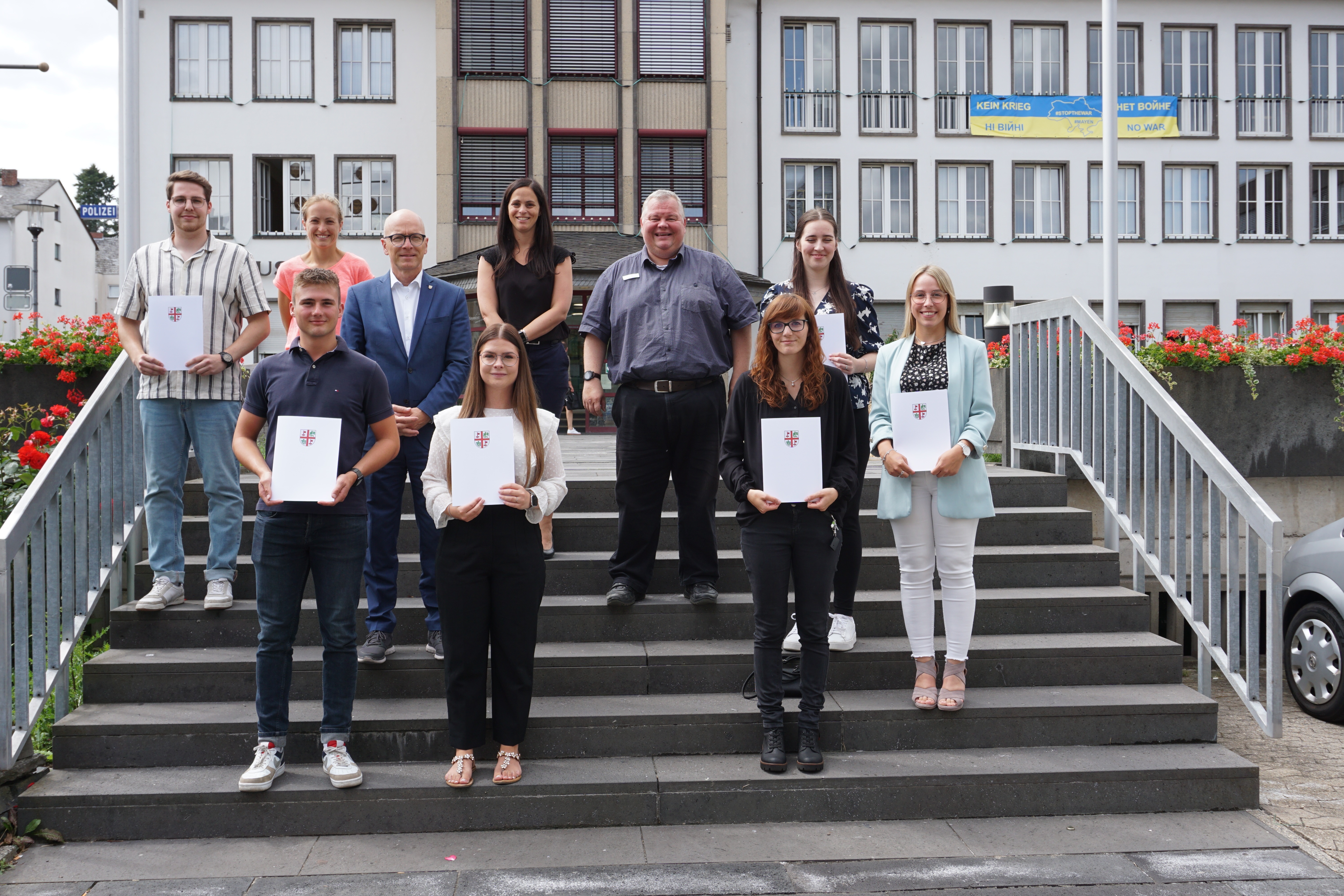 v.l.n.r.: Marc Schweitzer, Gleichstellungsbeauftragte Dr. Ina Rüber-Teke, Marius Luxem, Oberbürgermeister Dirk Meid, Ronja Dörpinghaus, Büroleiterin Jasmin Alter, Personalratsvorsitzender Wolfgang Goeken, Jana Kohnz, Lena Dillgard und Carolin Stephani Anwärter*innen und Führungskräfte vor dem Rathaus