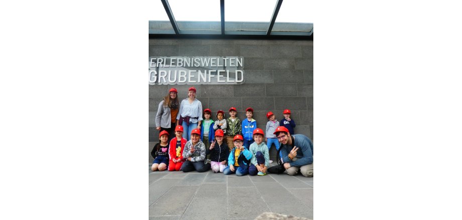 Die Maxi-Kinder der KiTa „In der Weiersbach“ mit ihren Erzieher*innen in den Erlebniswelten Grubenfeld Gruppenfoto vor dem Eingang des Grubenfeldes