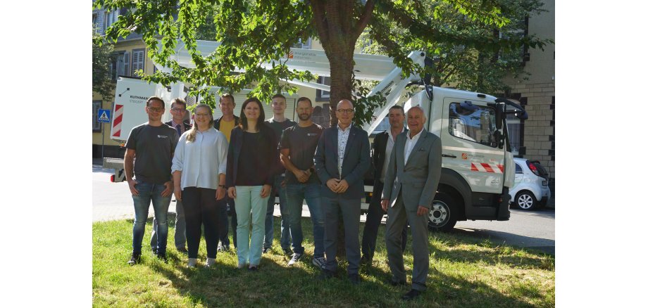 Vertreter der evm-Gruppe und der Stadt Mayen freuen sich auf die weitere Zusammenarbeit Gruppe von Personen steht unter einem Baum für ein Bild zusammen