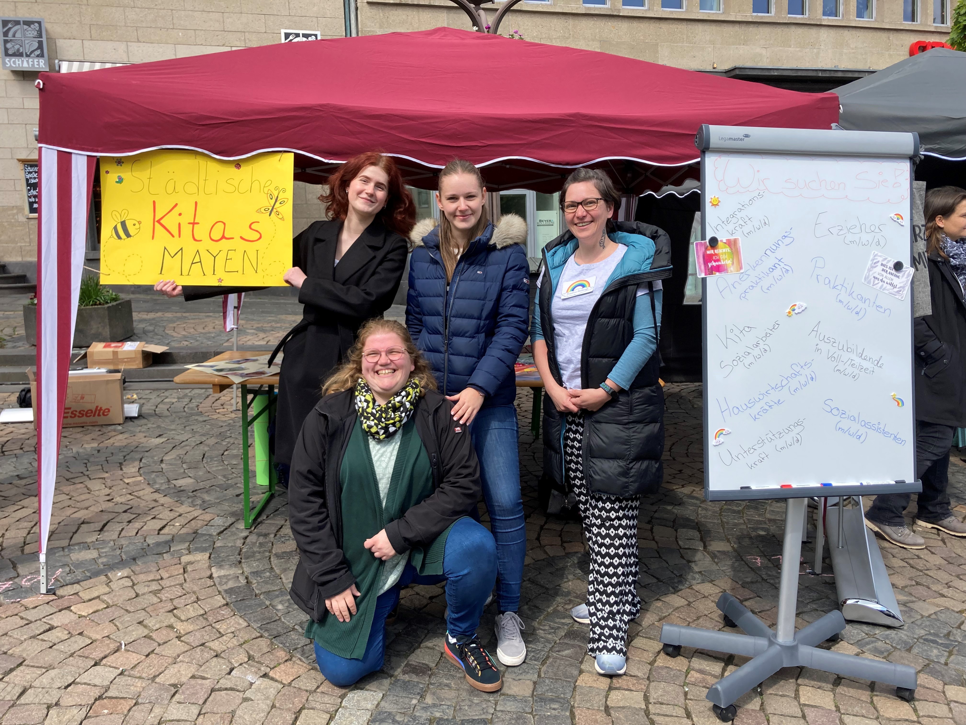 Informationen rund um die Ausbildungsmöglichkeiten bei den städtischen Kitas gab es am Stand der Messe Azubi Spots   4 Frauen vor einem Pavillon mit Plakaten