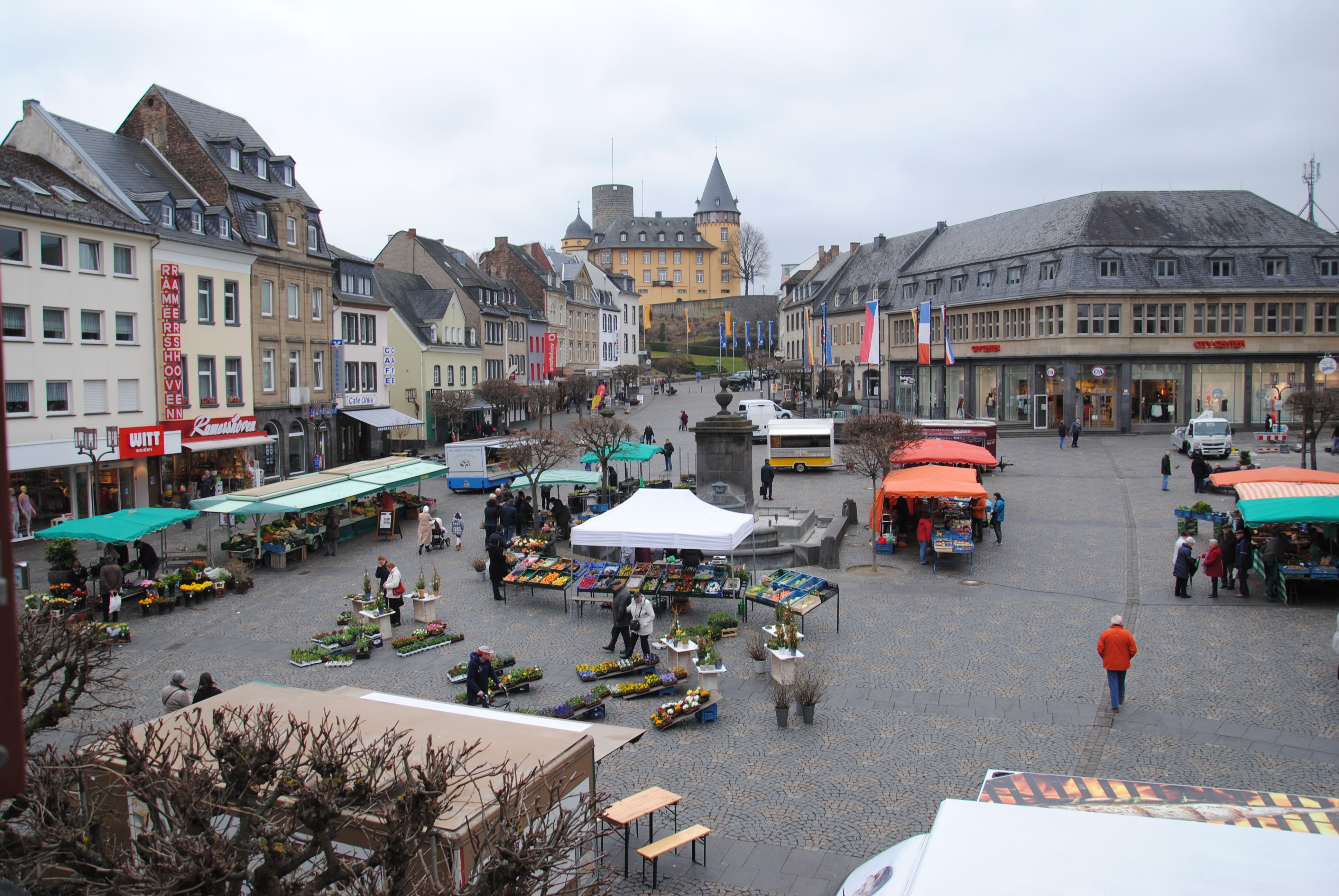 Marktstände auf einem Marktplatz - Menschen laufen herum 