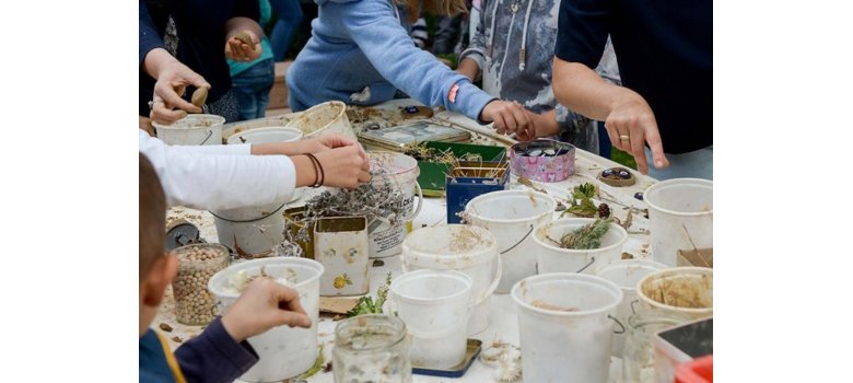 Viele Töpfe und Kinderhände auf einem Tisch - es wird gebastelt