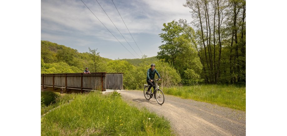 2 Radfahrer fahren einen Schotterweg entlang