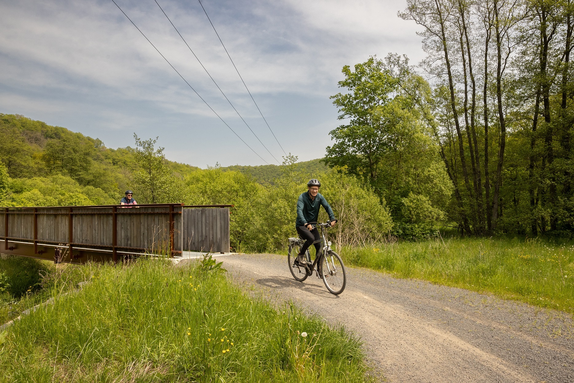 2 Radfahrer fahren einen Schotterweg entlang