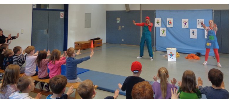 2 Personen führen etwas vor und Kinder machen mit