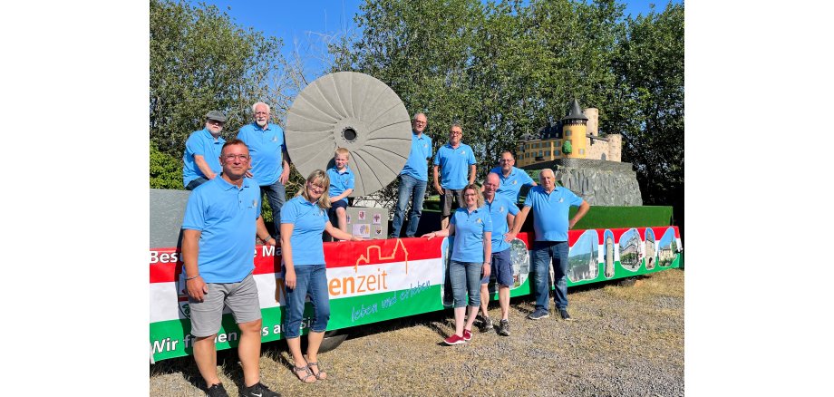 Personen stehen in einem blauen Poloshirt vor einem eigens gebaut Wagen zu Mayen