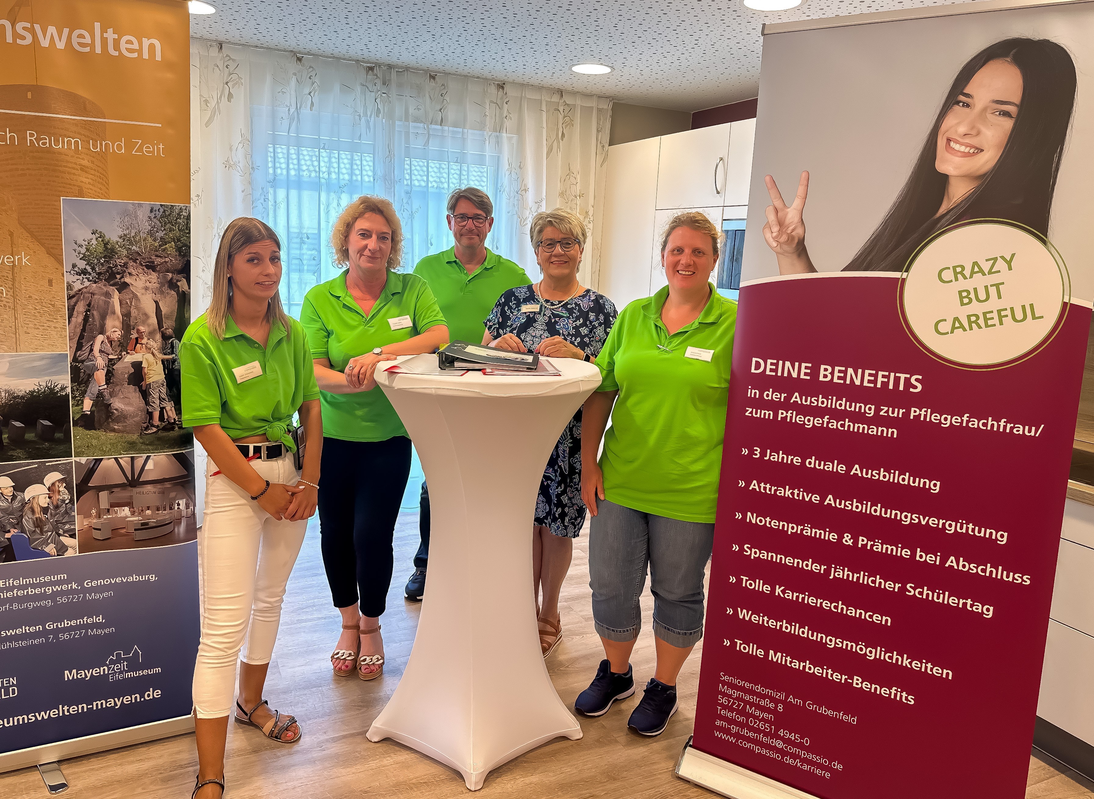 Fünf Personen stehen zwischen den Werbe-Roll-Ups