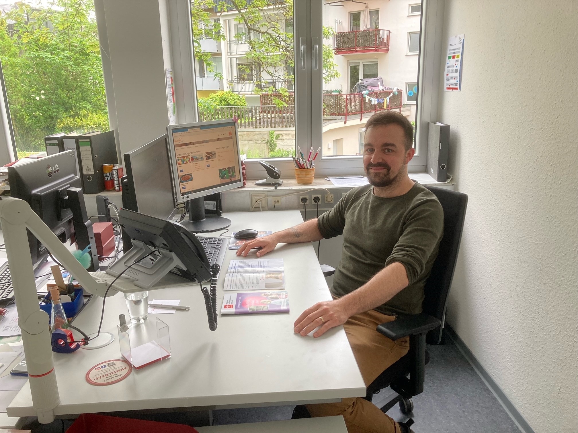 Mann sitzt an seinem Arbeitsplatz am Schreibtisch