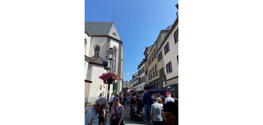 Viele Menschen in der Mayener Marktstraße bei blauem Himmel