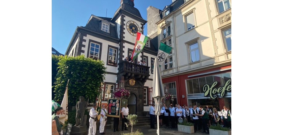 Zahlreiche Menschen stehen vor dem Alten Rathaus in Uniform und mit Fahnen