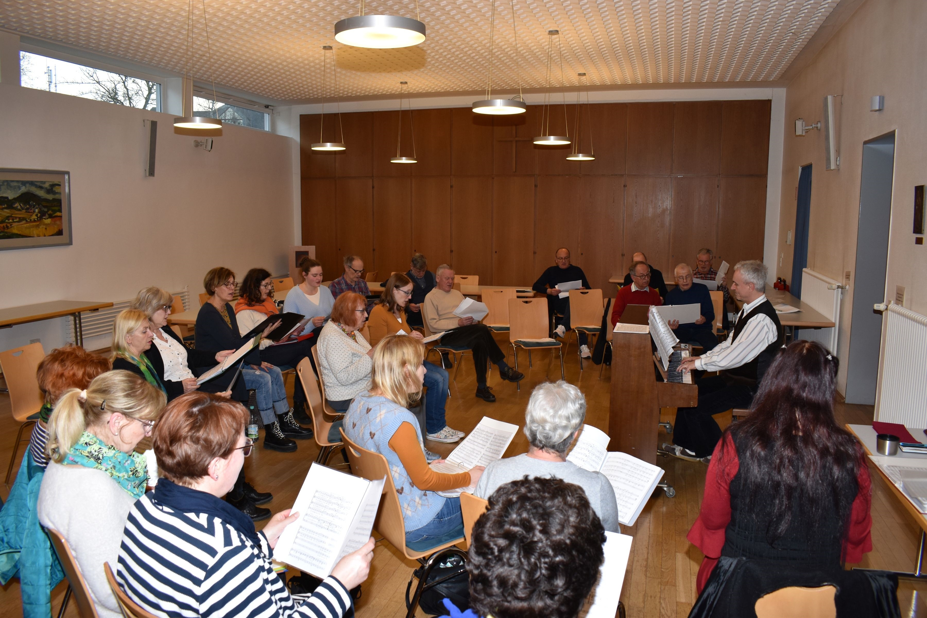 Personen sitzen in einem Kreis zusammen und proben