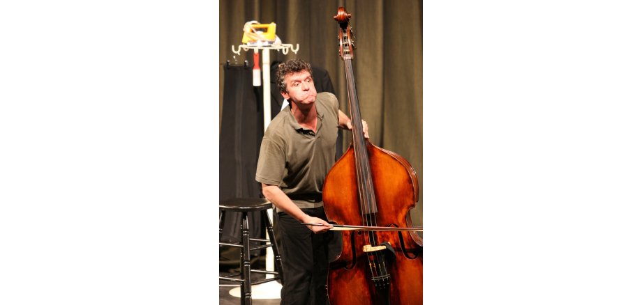 Michael Ophelders in „Der Kontrabass“ Mann, der eine Grimasse zieht, spielt Kontrabass