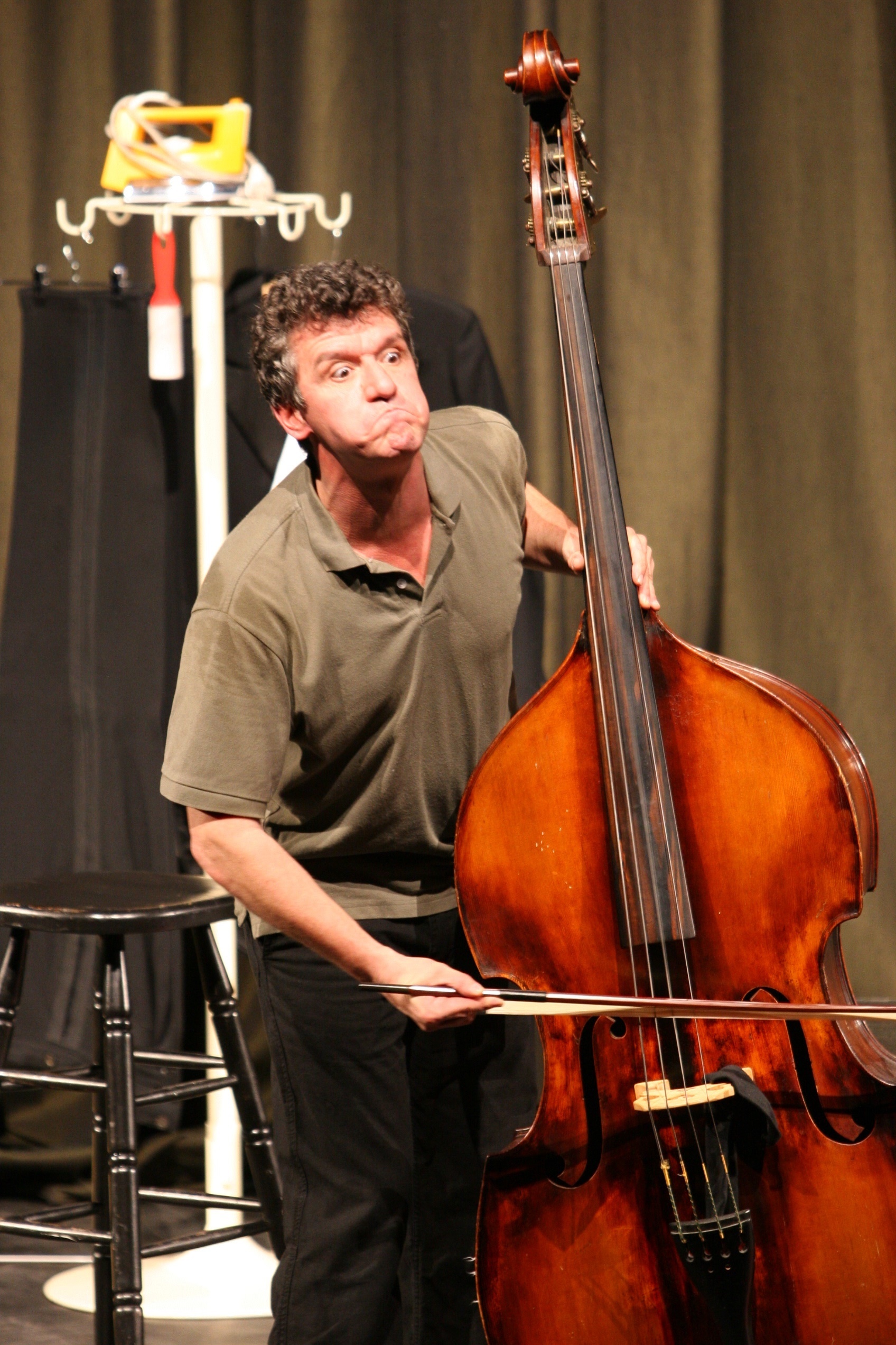 Mann, der eine Grimasse zieht, spielt Kontrabass