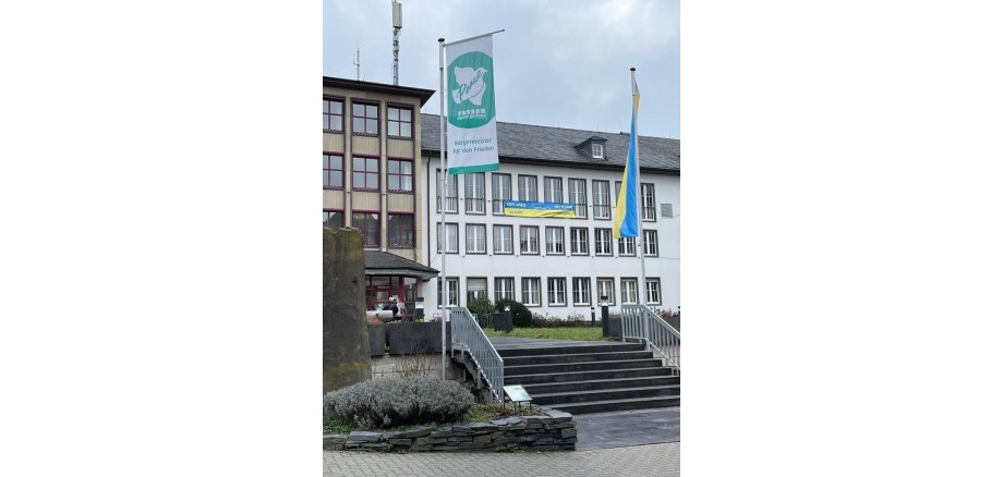 Das Rathaus der Stadt Mayen mit aufgehängten Banner gegen den Ukrainekrieg und ukrainischer Flagge