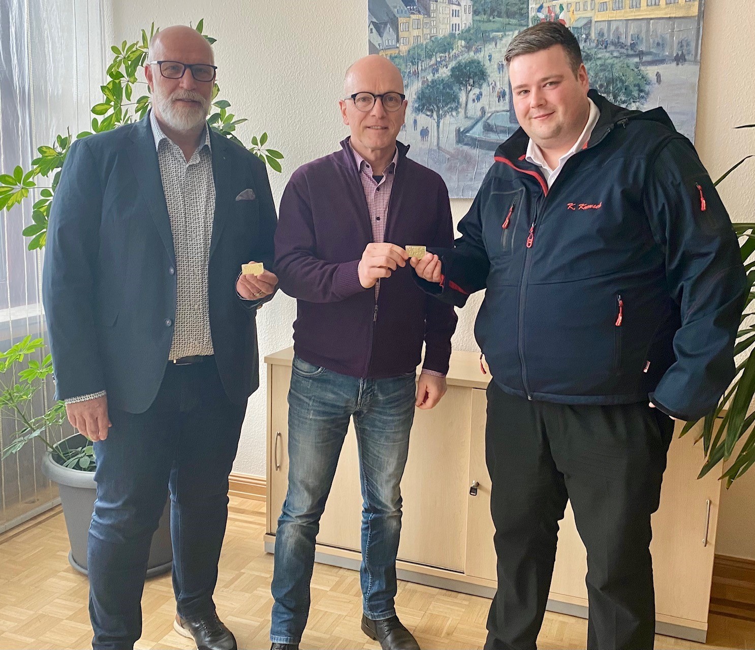 Drei Personen mit dem neuen Pin in den Händen