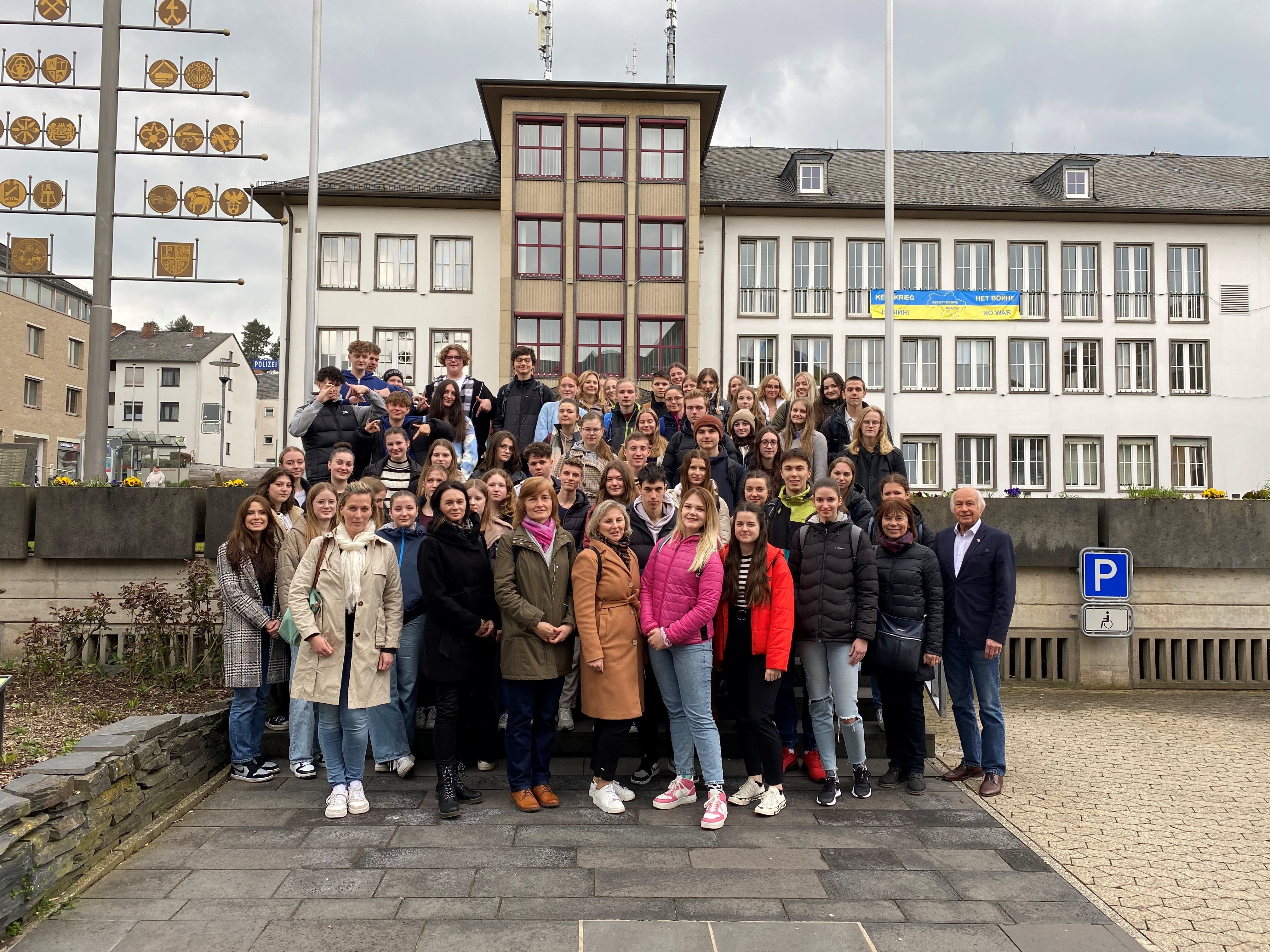 Eine Schülergruppe steht zusammen mit ihren Lehrkräften und  Bürgermeister Herrn Mauel vor dem Mayener Rathaus 
