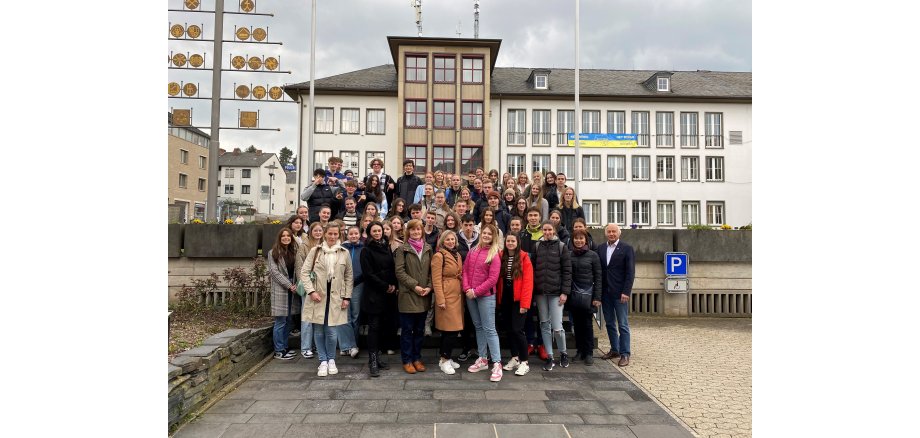 Eine Schülergruppe steht zusammen mit ihren Lehrkräften und  Bürgermeister Herrn Mauel vor dem Mayener Rathaus 