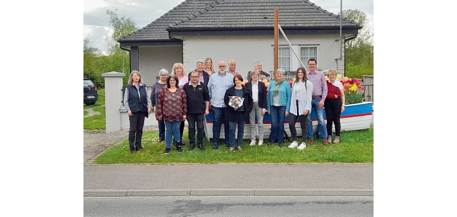 Eine Gruppe von Menschen steht vor einem Haus