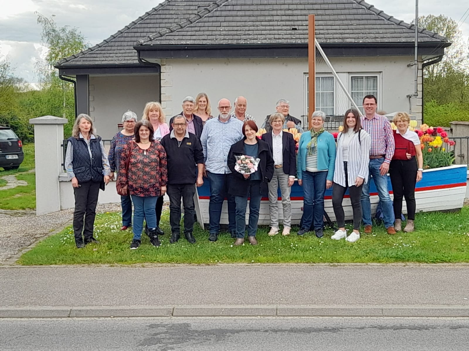 Eine Gruppe von Menschen steht vor einem Haus 