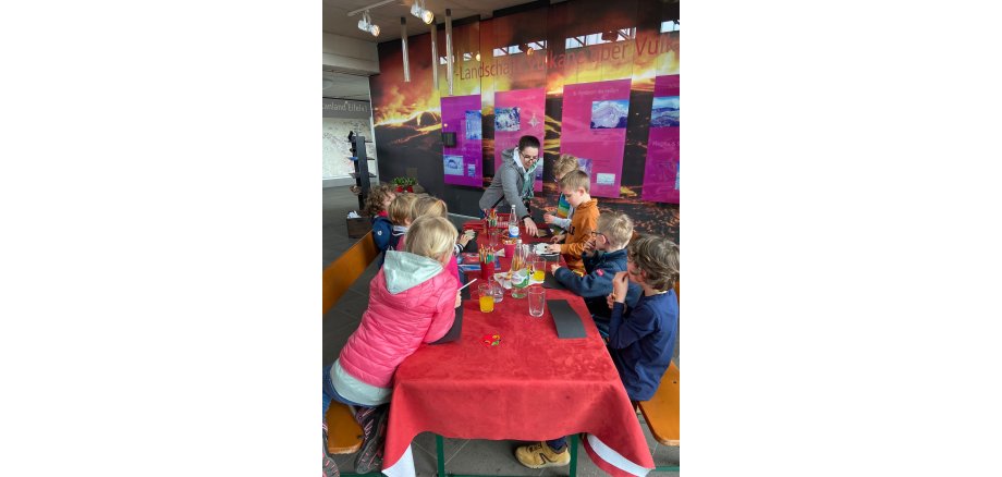 Tisch mit Kindern und einem Betreuer