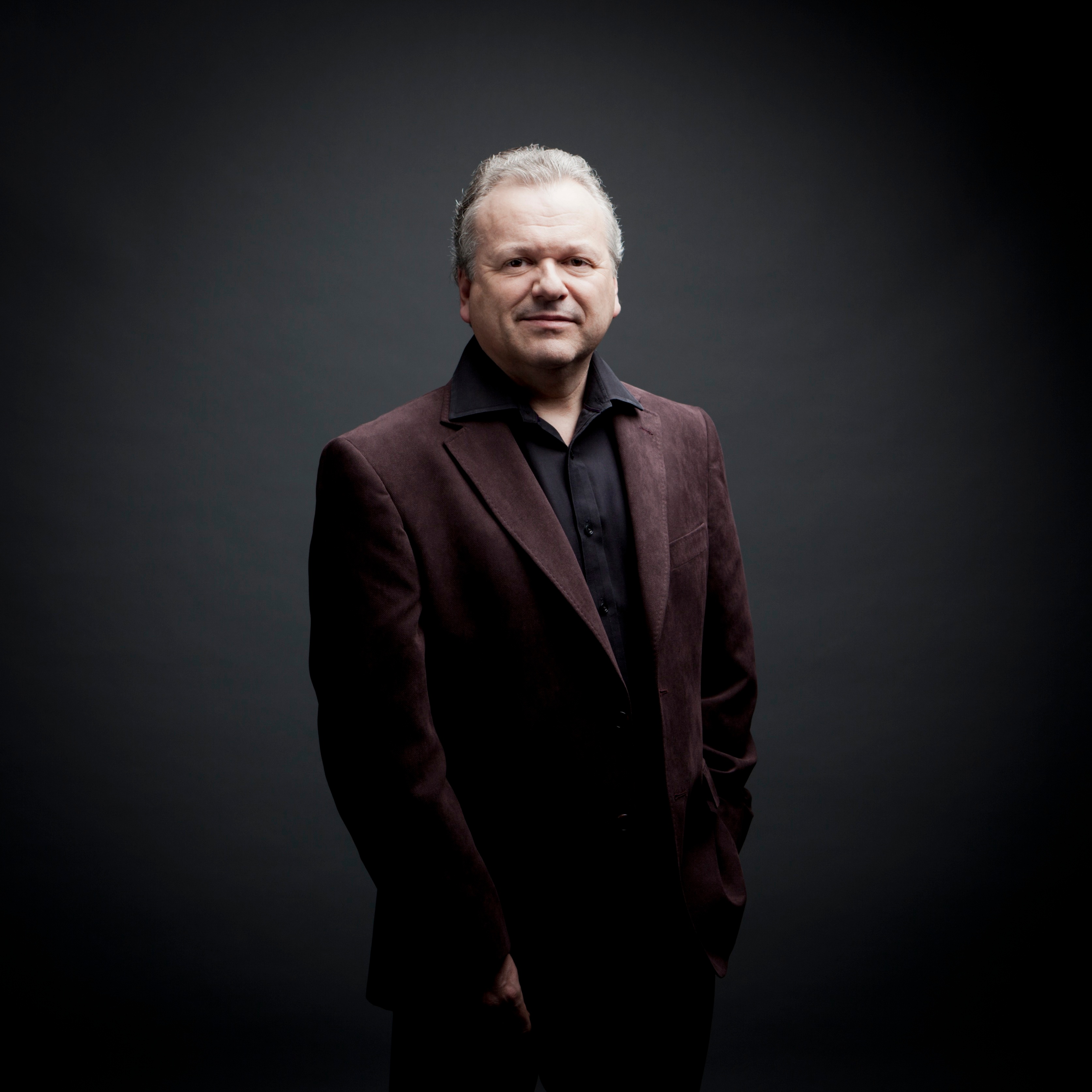 Mann steht vor grauem Hintergrund