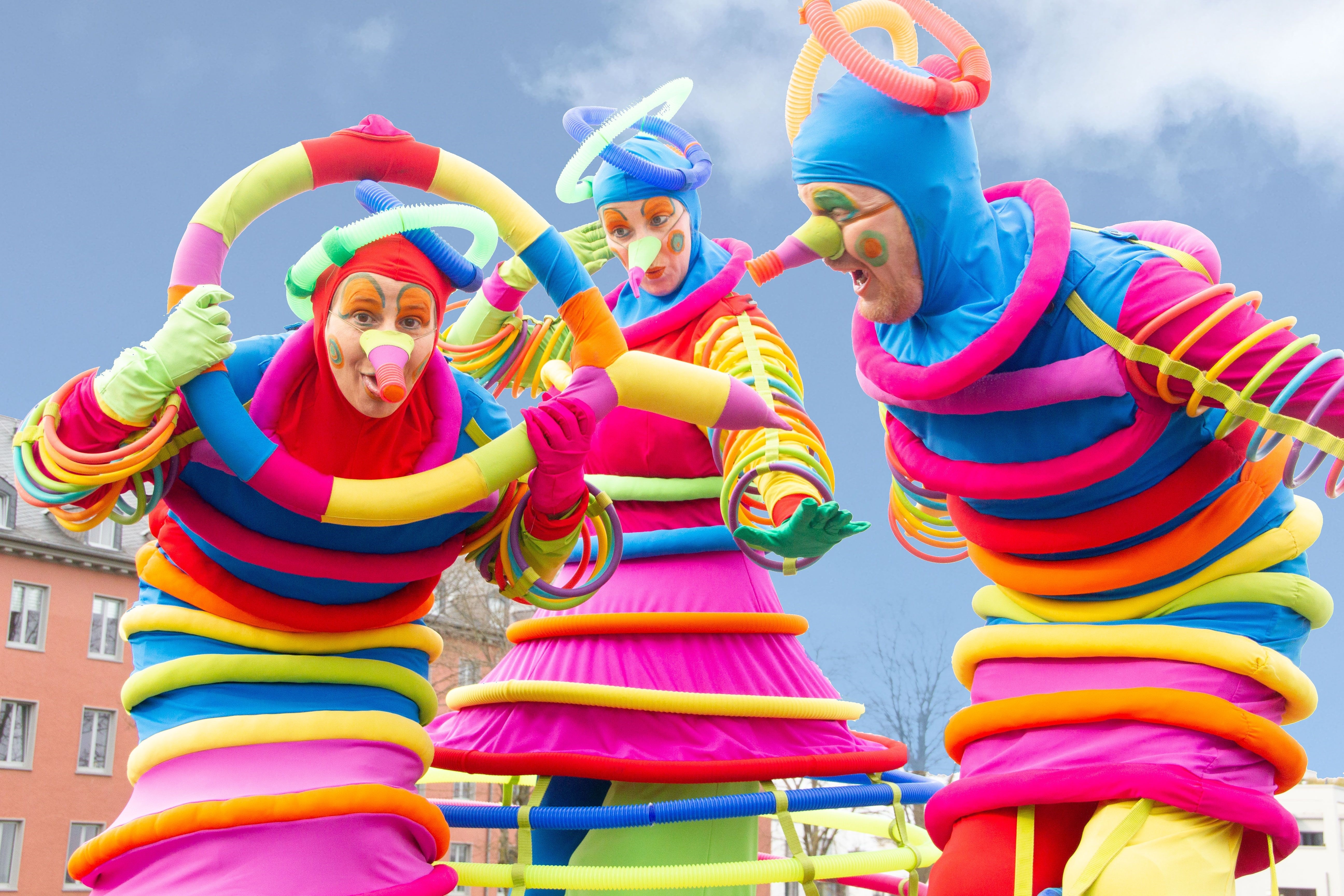 3 Personen in bunten Kostümen