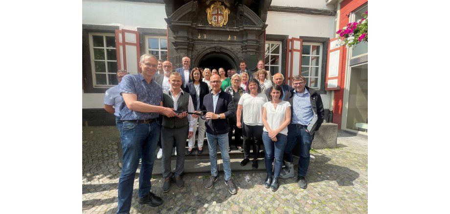 Gruppe von Personen vor dem Alten Rathaus - 2 Personen übergeben sich einen symbolischen Schlüssel