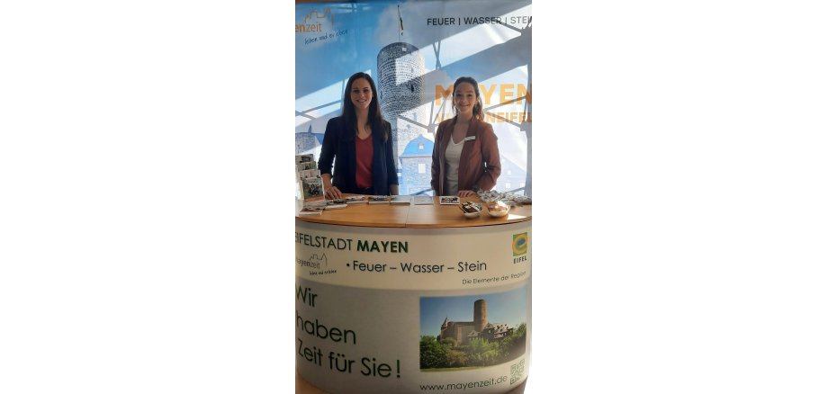 2 Personen stehen an einem Messestand