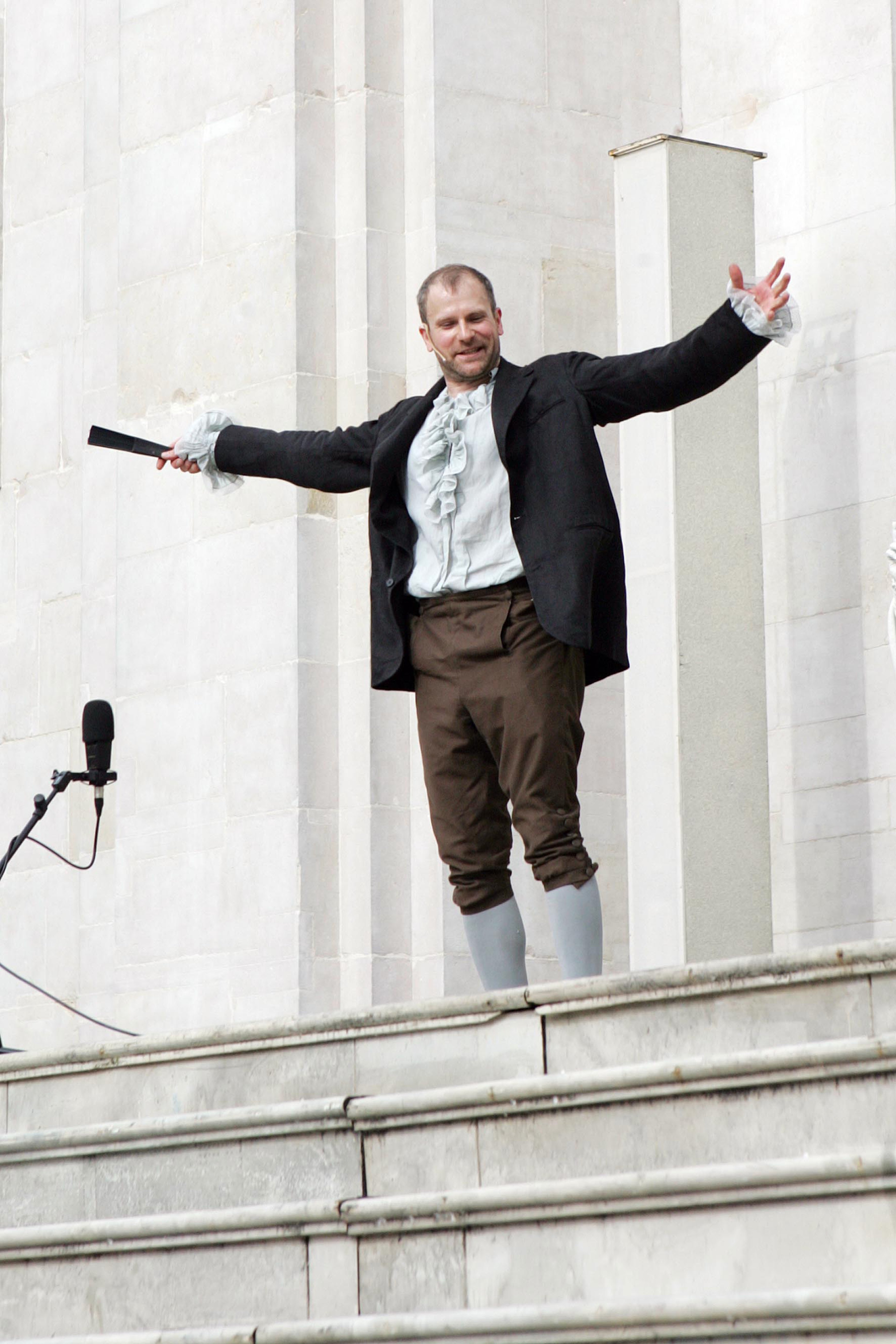 Mann steht auf einer Treppe und wirft die Arme nach oben