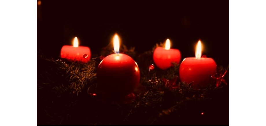 Ein Adventskranz mit vier brennenden Kerzen