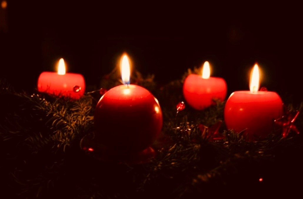 Ein Adventskranz mit vier brennenden Kerzen