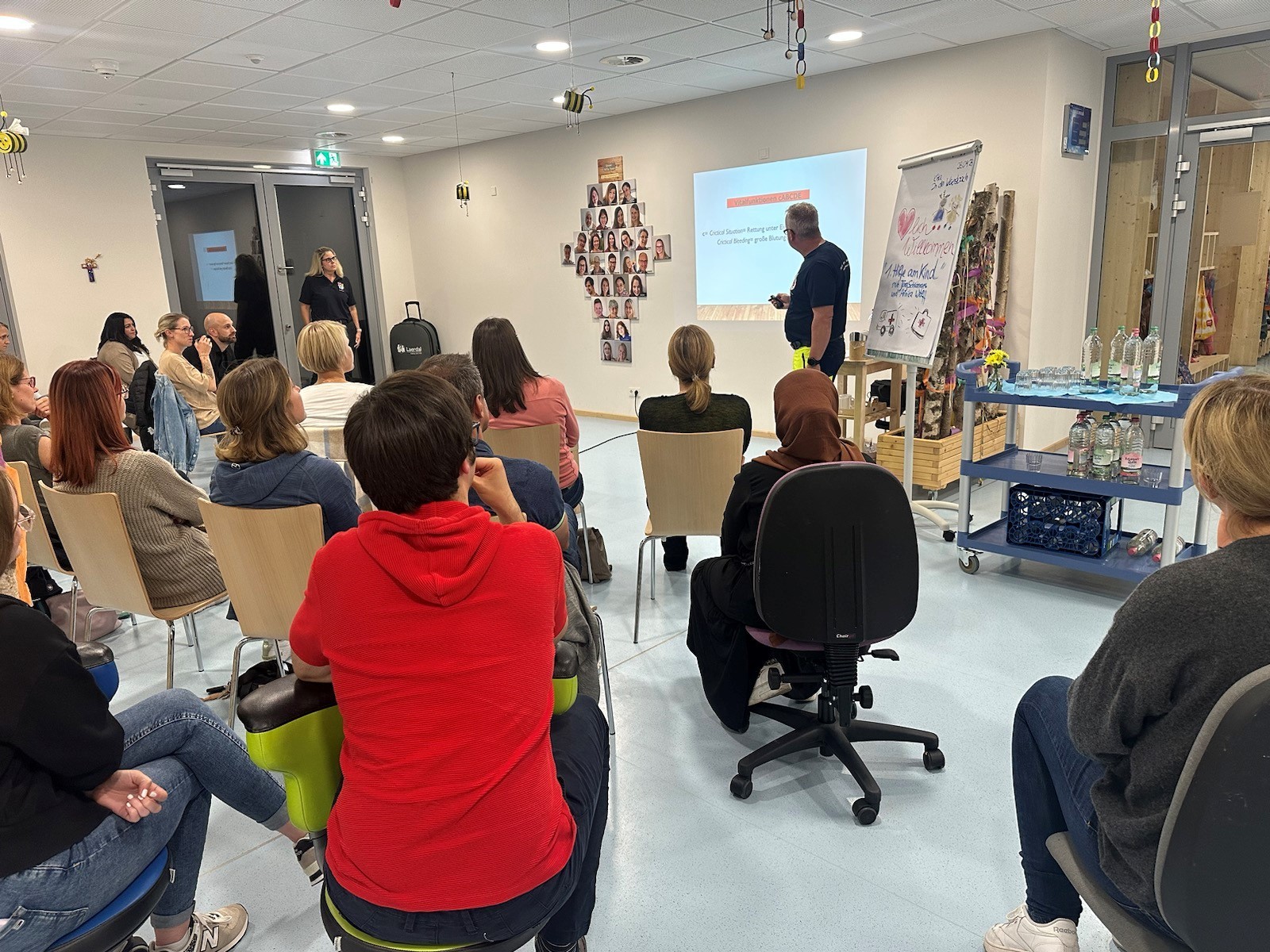 Viele Personen sitzen zusammen und lauschen einem Vortrag