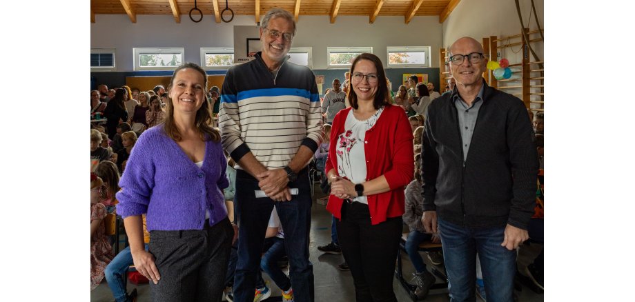 Vier Personen stehen zu einem Gruppenbild zusammen