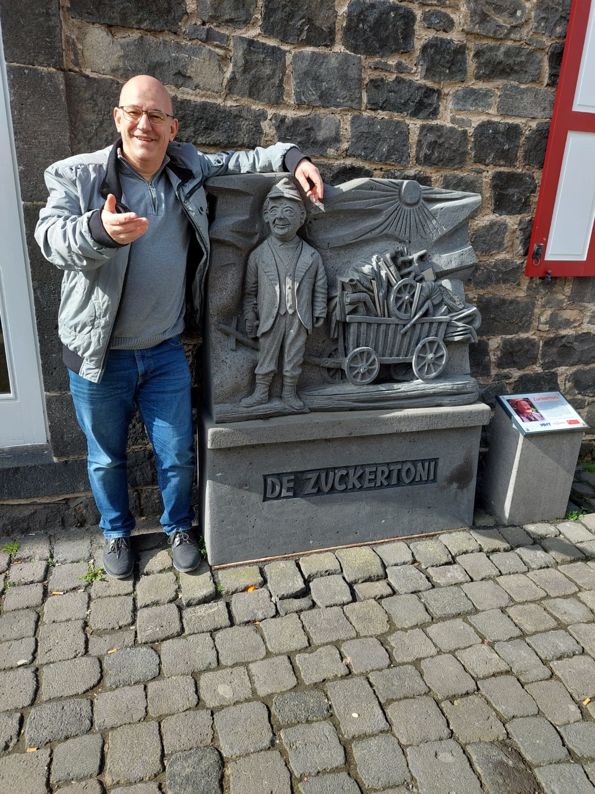 Ein Mann steht an einer Steinfigur