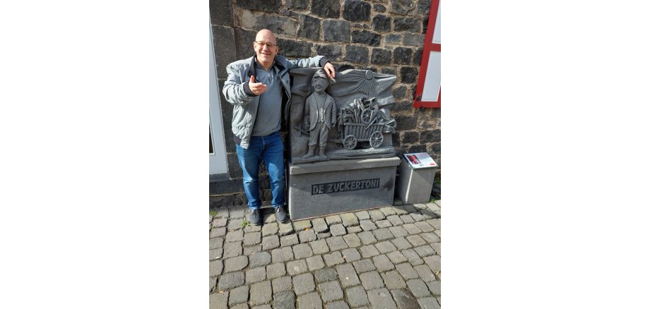 Werner Blasweiler – ein echter Mayener Jung! Ein Mann steht an einer Steinfigur