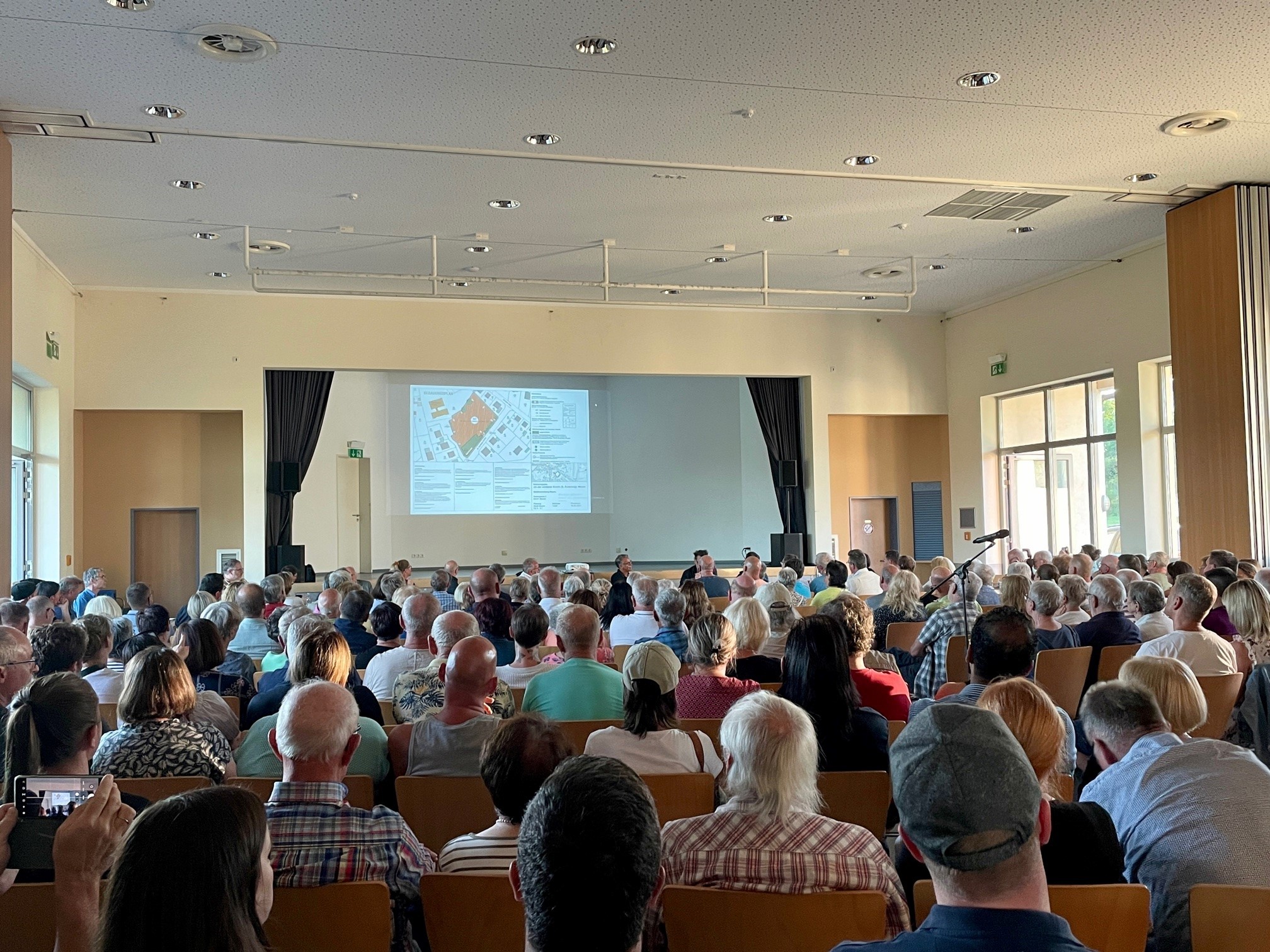 Einwohner*innen von Hausen bei der Versammlung über das Bauvorhaben